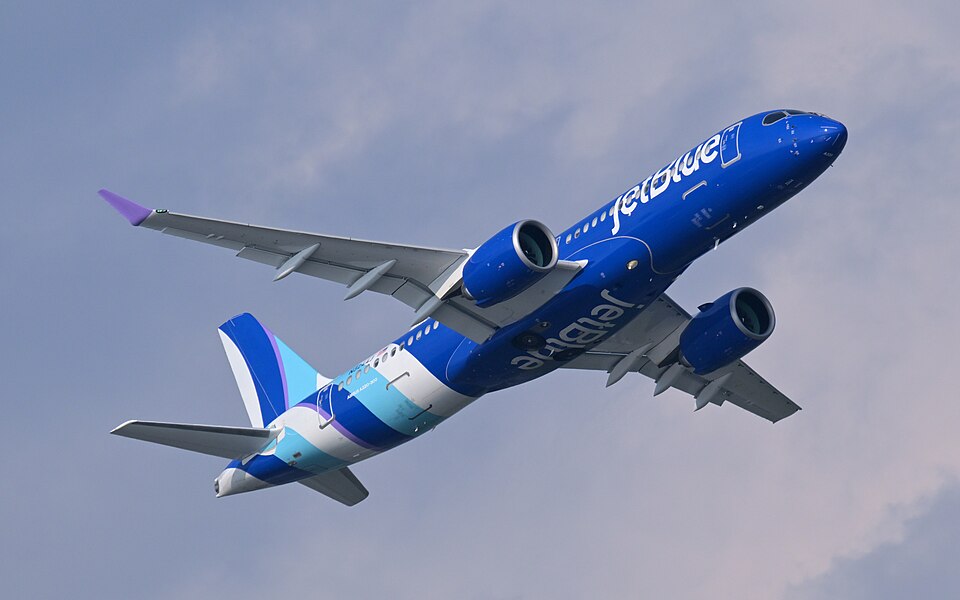 A JetBlue Airbus A220-300 climbing after takeoff